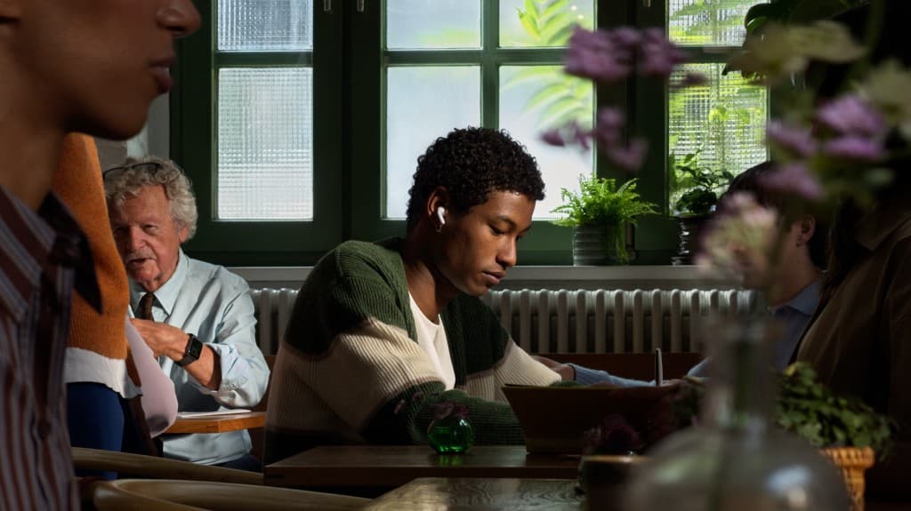Person wearing AirPods in a cafe lifestyle scene