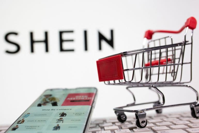 SHEIN cart open on a phone beside a laptop keyboard