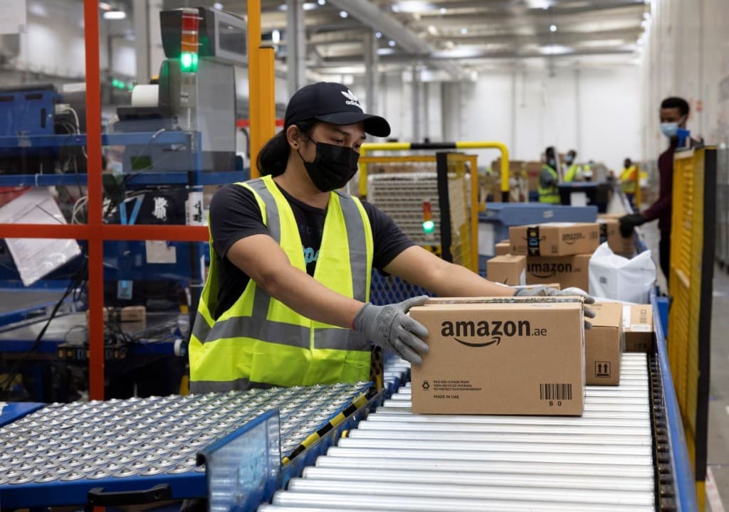 Warehouse worker moving a parcel onto a conveyor - illustrative logistics visual