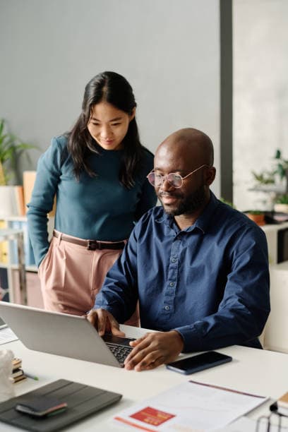 Colleagues collaborating on a laptop in a modern office