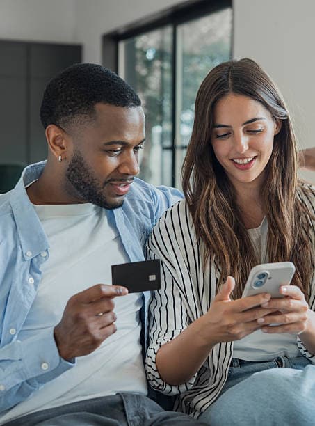 Couple shopping online together with a phone and card