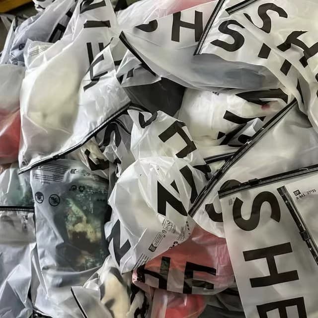 Stack of sealed SHEIN branded apparel poly bags