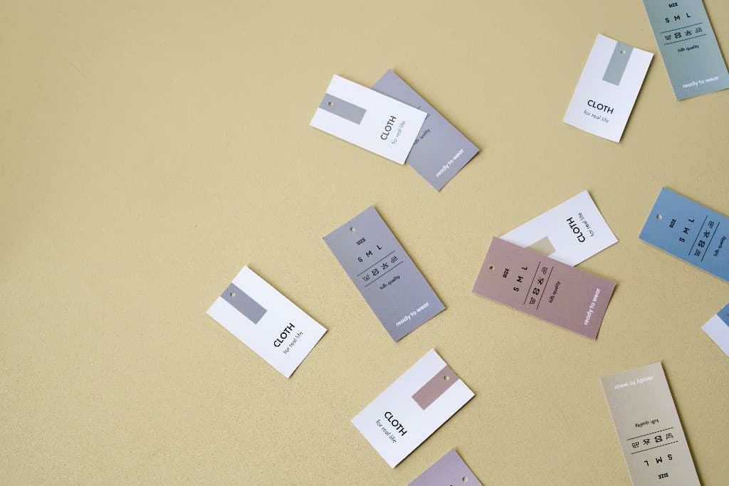 Clothing hangtags with size and care symbols on a neutral background