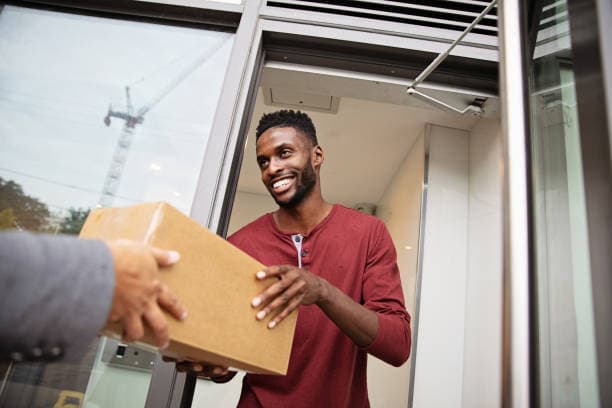 Smiling shopper receiving a parcel at the door
